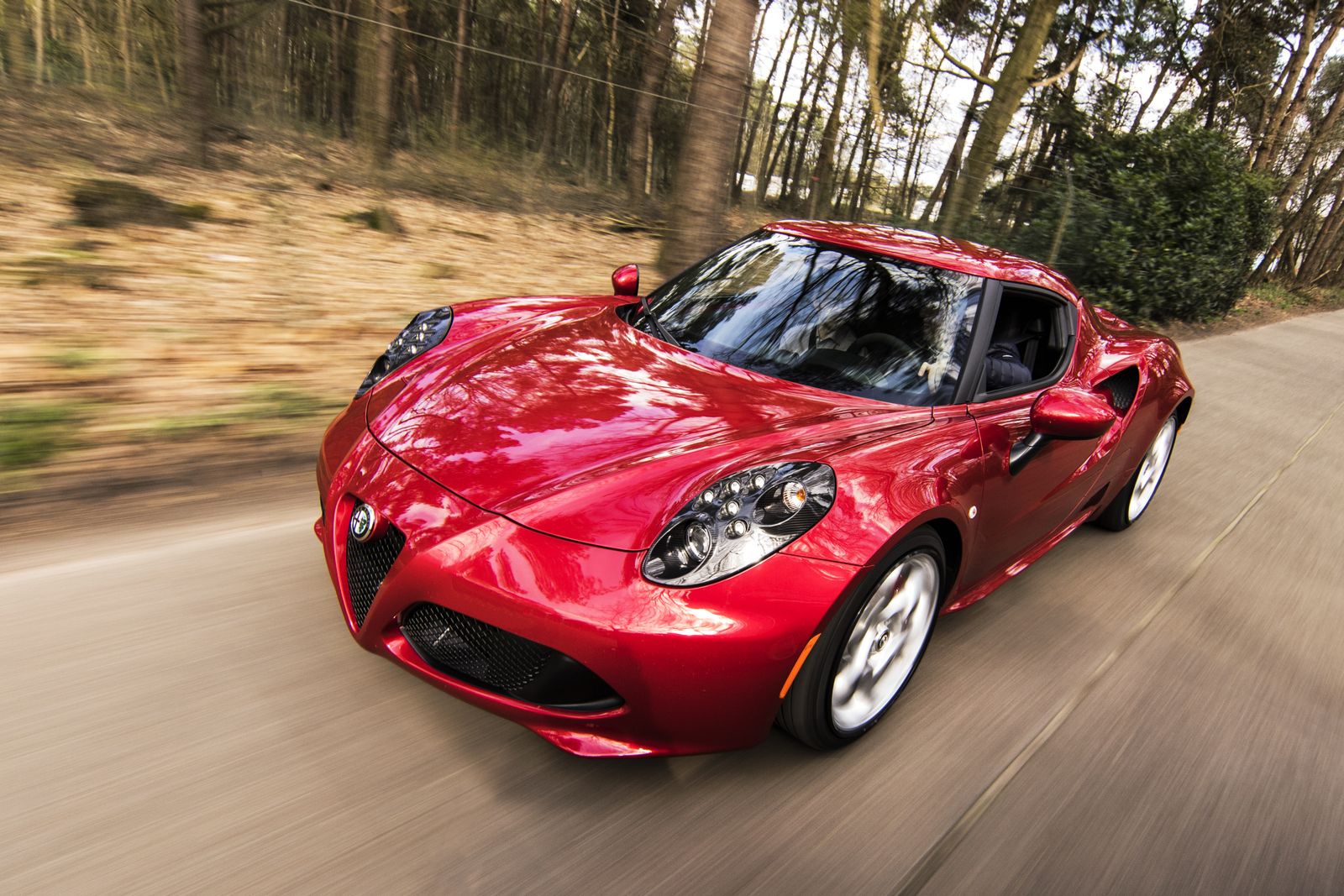Red sports car driving on an open road